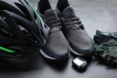 Photo of Different cycling accessories on grey table, closeup