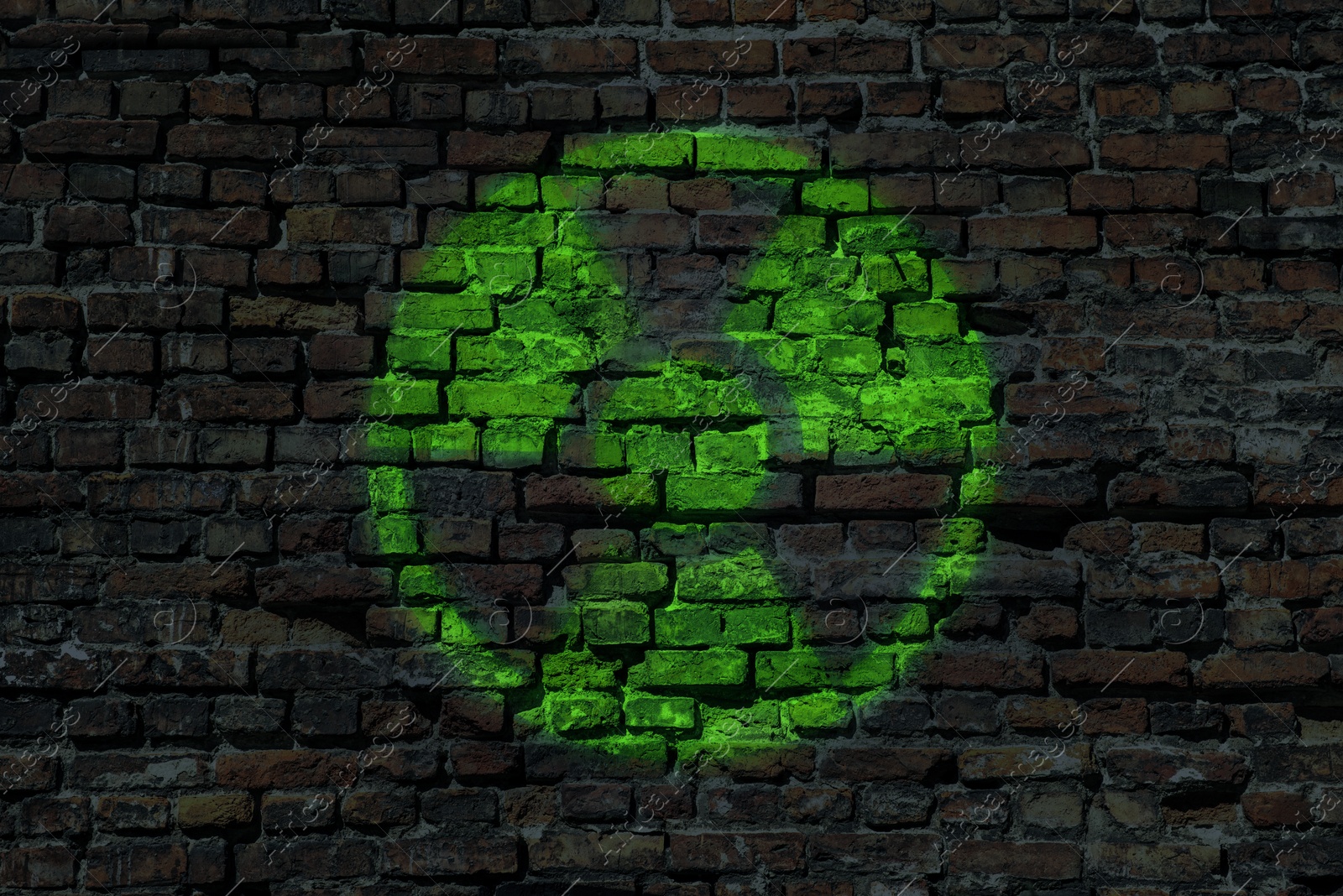 Image of Radioactive sign on brick wall. Hazard symbol