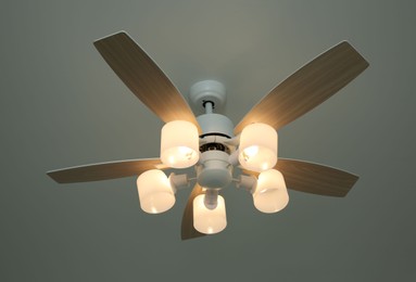 Photo of Ceiling fan with lamps indoors, low angle view