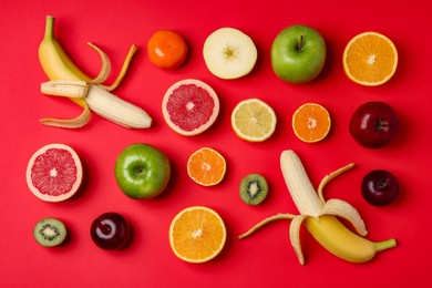 Photo of Different ripe fruits on red background, flat lay