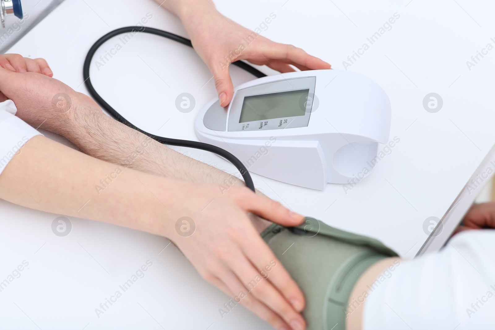 Photo of Doctor checking blood pressure of man in clinic, closeup