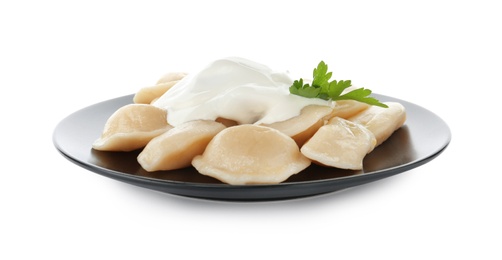 Photo of Delicious cooked dumplings with sour cream on white background