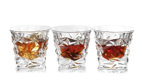 Glasses of scotch whiskey on white background