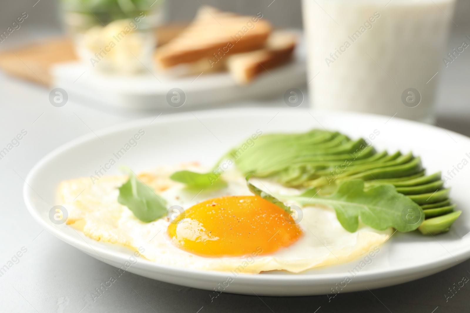 Photo of Tasty breakfast with fried egg and avocado on table, closeup
