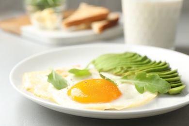 Photo of Tasty breakfast with fried egg and avocado on table, closeup