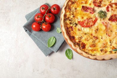 Tasty quiche with tomatoes and cheese served on light table, flat lay. Space for text