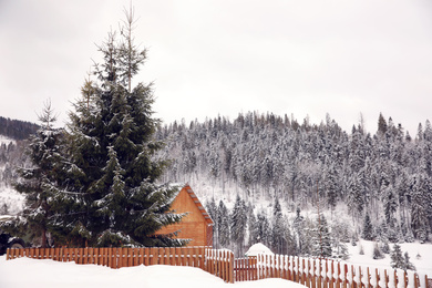 Beautiful landscape with cottage on snowy winter day