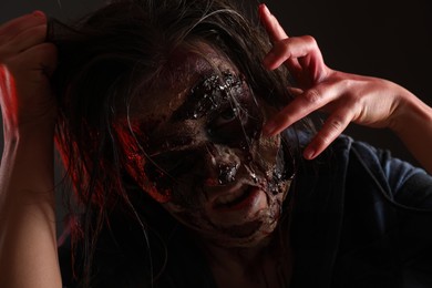 Photo of Scary zombie on dark background, closeup. Halloween monster