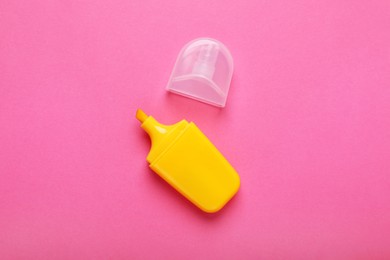 Photo of Yellow marker with cap on pink background, top view