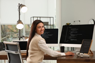 Happy programmer working at desk in office