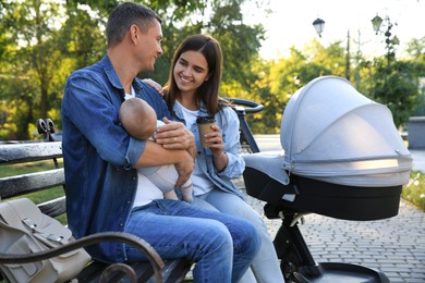 Photo of Happy parents with their baby on bench in park