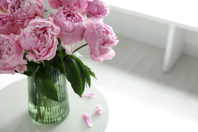 Bouquet of beautiful peonies on table indoors, closeup. Space for text