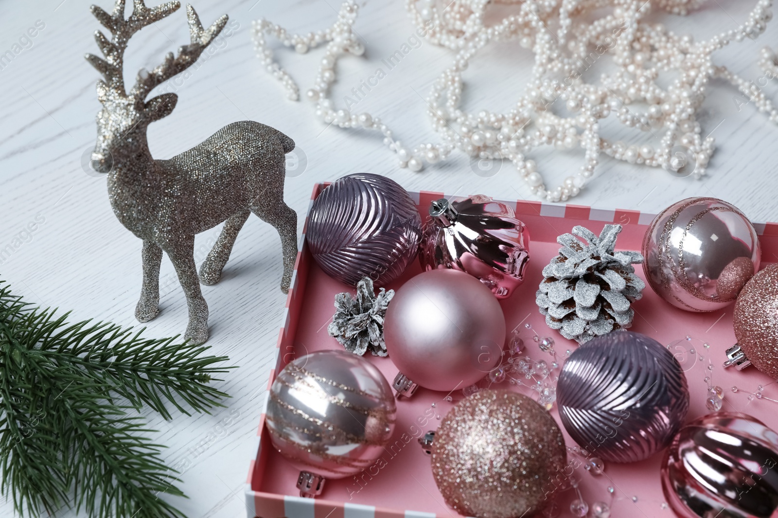 Photo of Composition with beautiful Christmas baubles on white wooden table