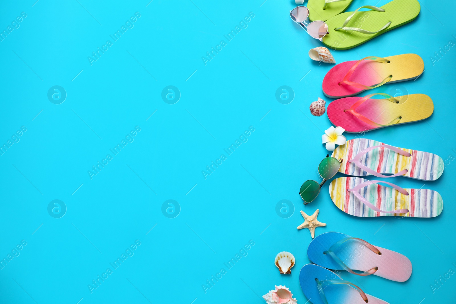 Photo of Flat lay composition with different flip flops on blue background, space for text. Summer beach accessories