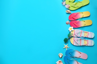 Photo of Flat lay composition with different flip flops on blue background, space for text. Summer beach accessories