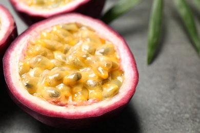 Photo of Half of passion fruit (maracuya) on grey table, closeup