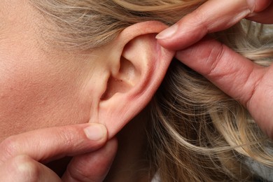 Photo of Closeup view of woman touching her ear