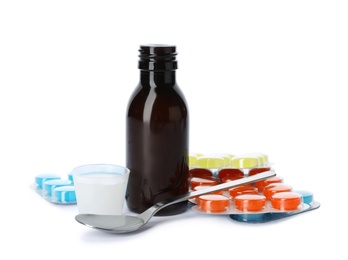 Photo of Cough syrup and different pills on white background