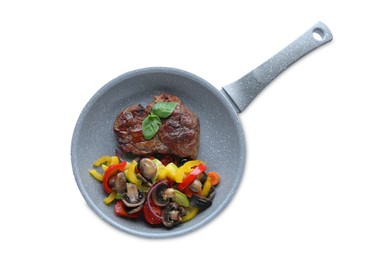 Photo of Tasty fried steak with vegetables in pan isolated on white, top view