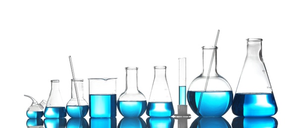 Photo of Laboratory glassware with liquid on table against color background. Chemical analysis