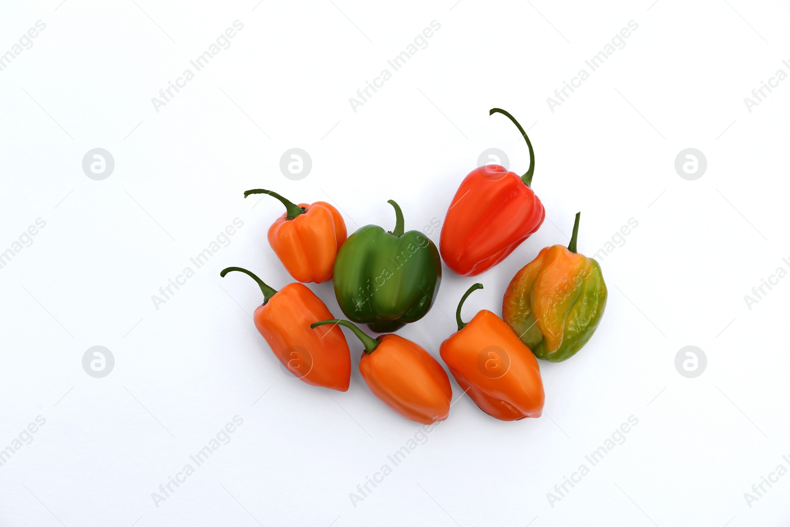 Photo of Different hot chili peppers on white background, flat lay