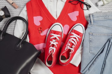 Photo of Pair of stylish red sneakers, clothes and accessories on light grey fabric, flat lay
