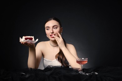 Fashionable photo of attractive woman with her Birthday cake and glass of wine on black background