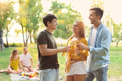 Happy friends having picnic in park on sunny day