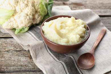 Bowl with tasty puree and cauliflower on wooden table