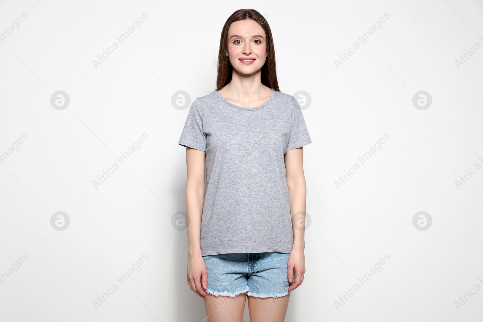 Photo of Young woman in t-shirt on light background. Mock up for design