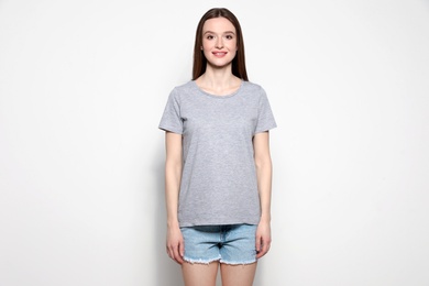 Photo of Young woman in t-shirt on light background. Mock up for design