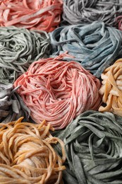 Photo of Rolled pasta painted with food colorings as background, closeup