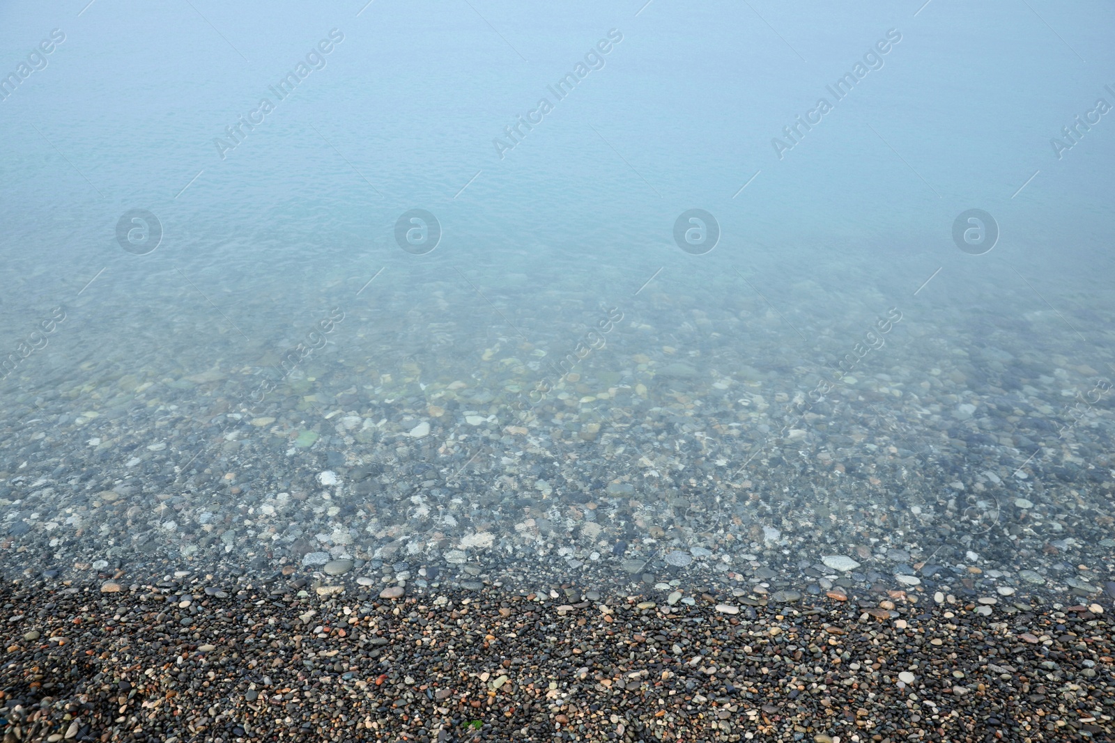 Photo of Beautiful view of sea tide on shingle beach. Summer vacation