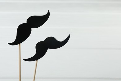 Photo of Fake paper mustaches party props on white background. Space for text