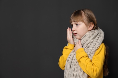 Photo of Cute little girl coughing against dark background. Space for text