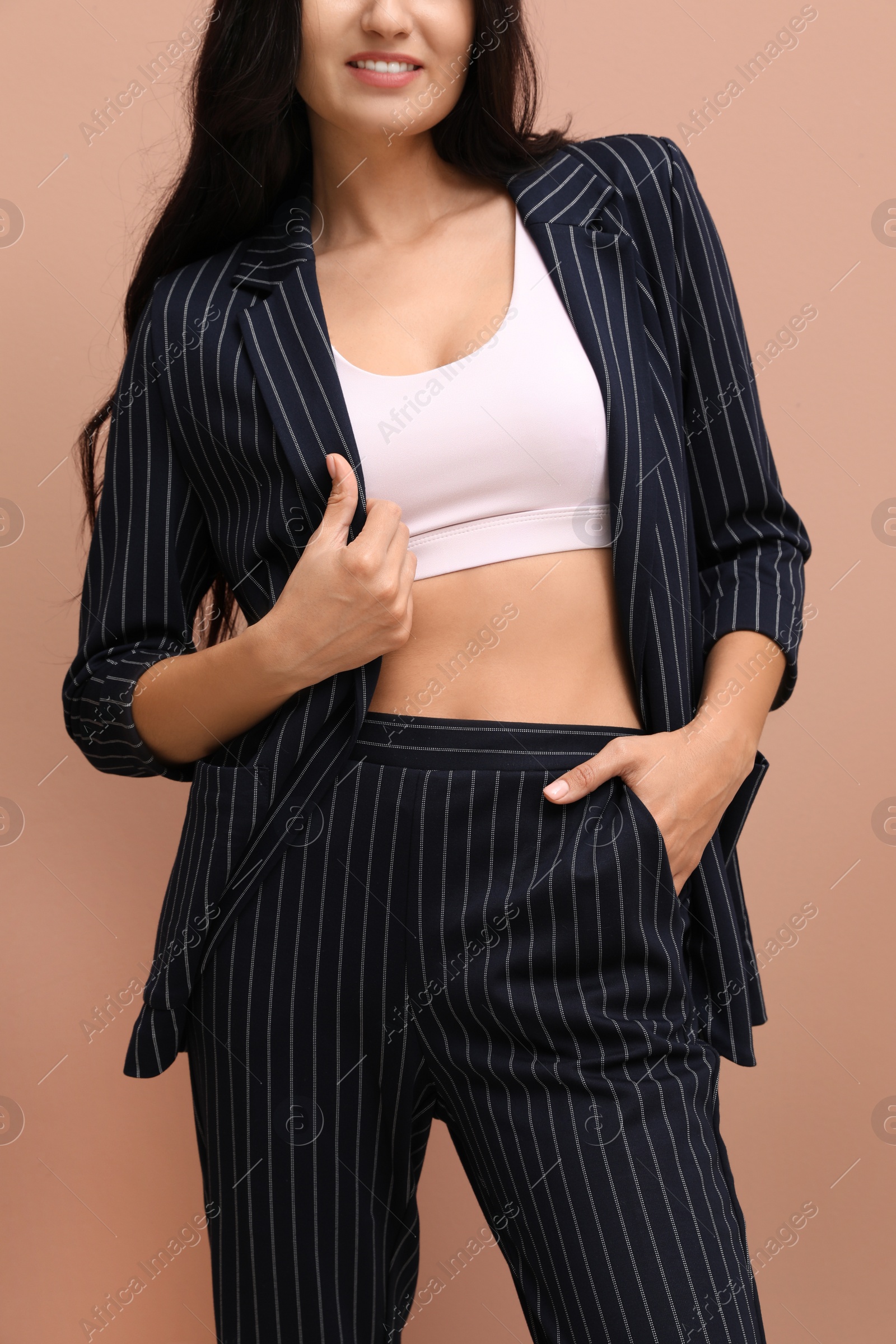 Photo of Woman in formal suit on pale pink background, closeup. Business attire