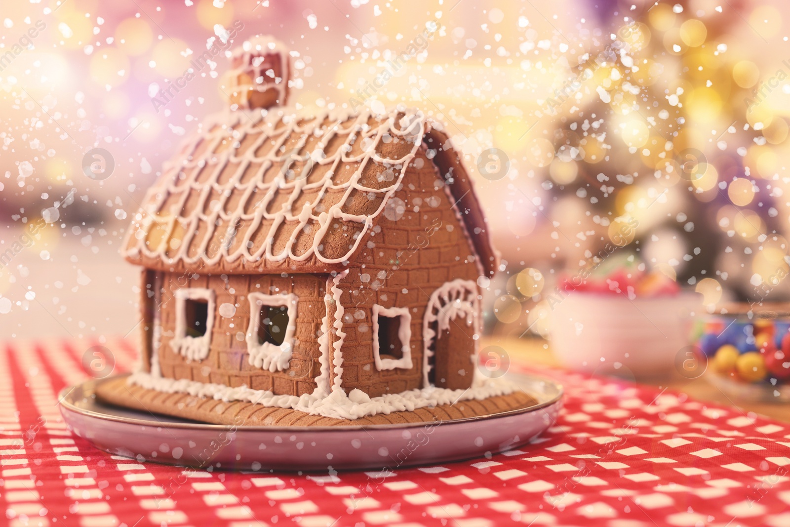 Image of Beautiful gingerbread house decorated with icing on table indoors, space for text