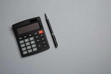 Photo of Calculator and pen on light grey background, flat lay with space for text