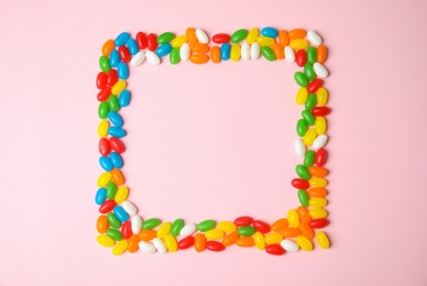 Frame of jelly beans on color background, top view. Space for text