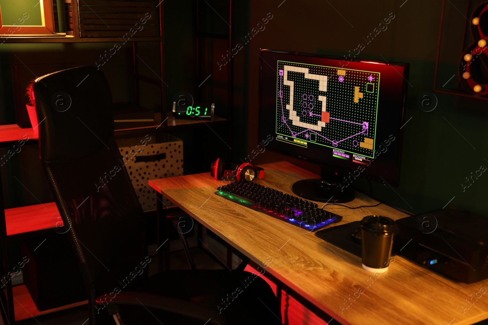 Photo of Modern computer and RGB keyboard on wooden table in dark room