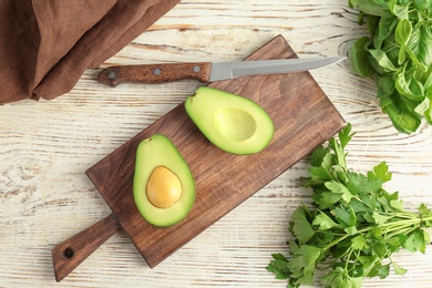 Flat lay composition with ripe avocado, basil, parsley on wooden background