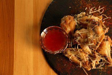 Tasty BBQ wings with red sauce served on table in cafe, top view