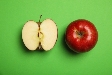 Flat lay composition with ripe juicy red apples on green background