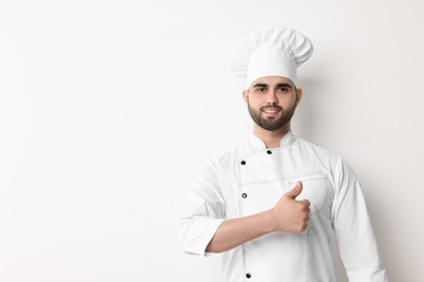 Photo of Professional chef showing thumb up on white background