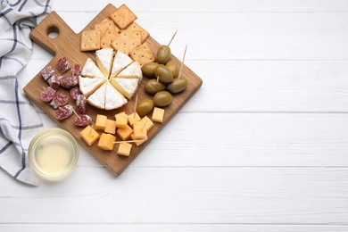 Photo of Toothpick appetizers. Pieces of sausage, cheese and honey on white wooden table, flat lay