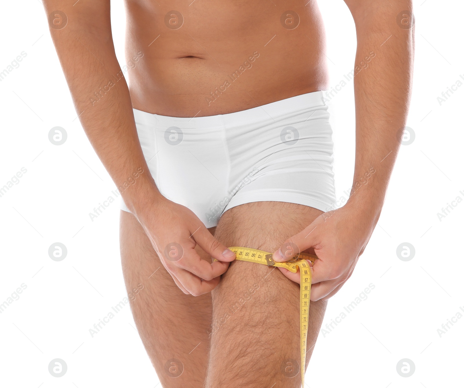 Photo of Fit man measuring his thigh on white background, closeup. Weight loss