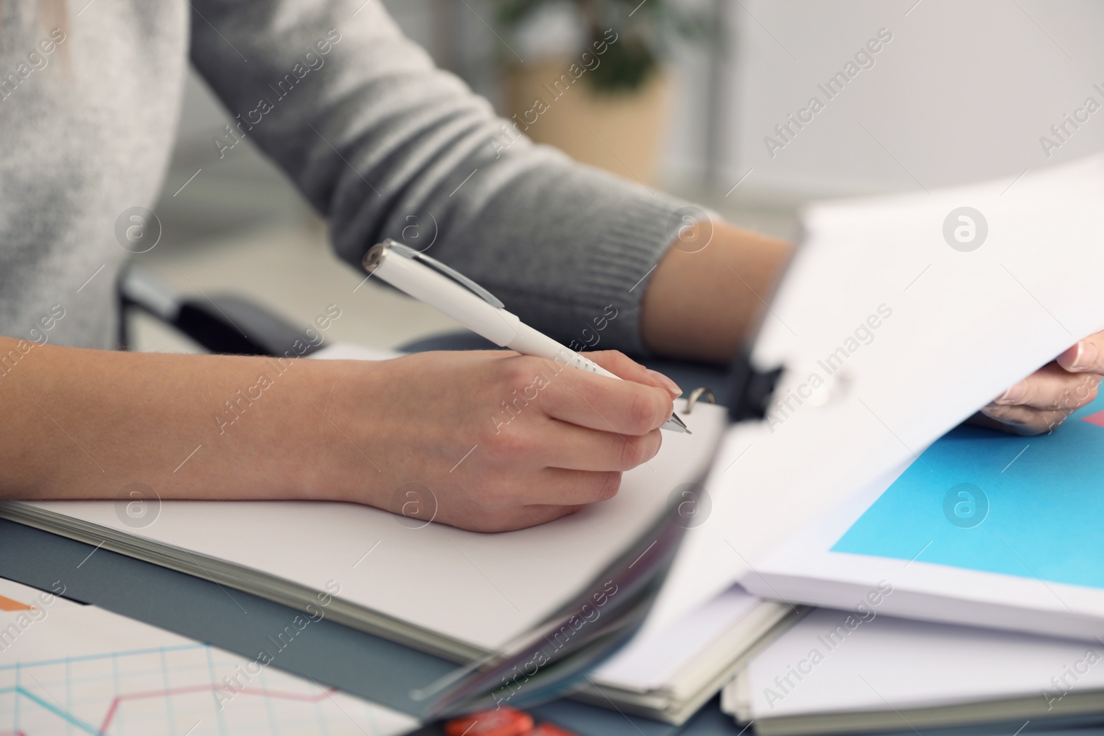 Photo of Office employee working with documents at table, closeup
