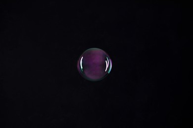 Photo of One beautiful soap bubble on black background