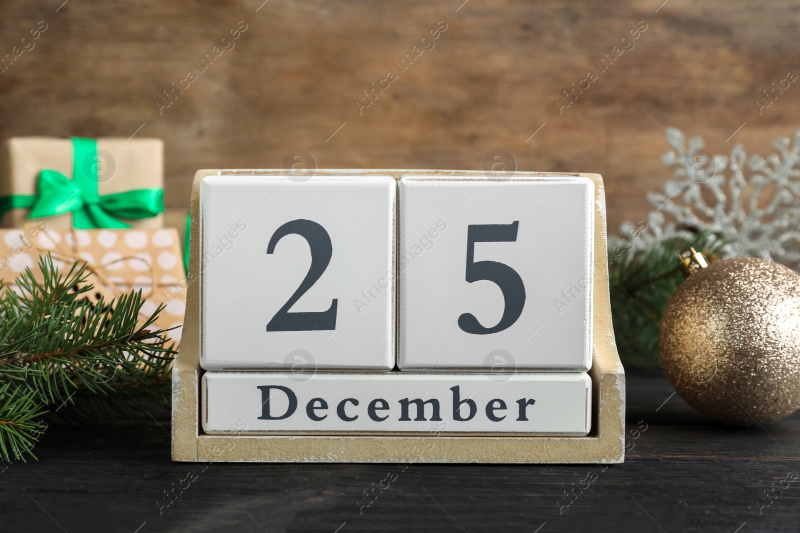 Photo of Block calendar and festive decor on black wooden table. Christmas countdown