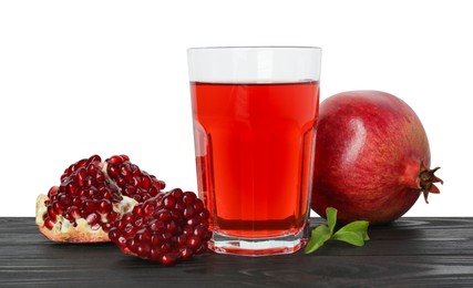 Photo of Refreshing pomegranate juice in glass, leaves and fruits on black wooden table against white background